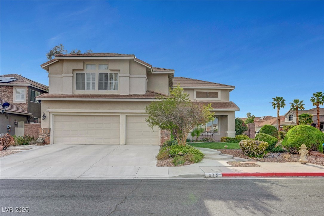 Two-story stucco home with a three-car garage and desert landscaping at 215 Sawtelle St in Henderson